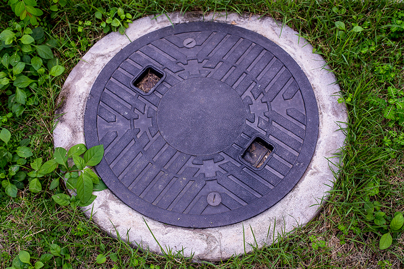 Lid to a septic tank seen while preforming home inspection services